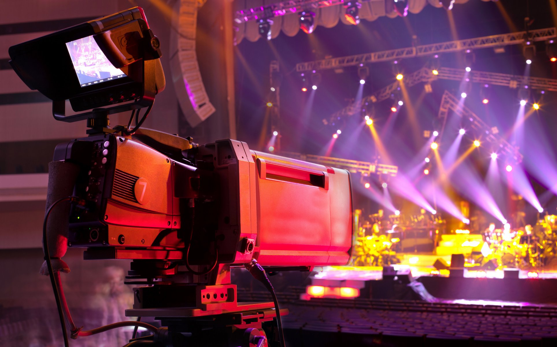 hi-tech technology video camera professional video tv camera shooting music concert stage hall lighting appliances colored lights blur bokeh close up wallpaper