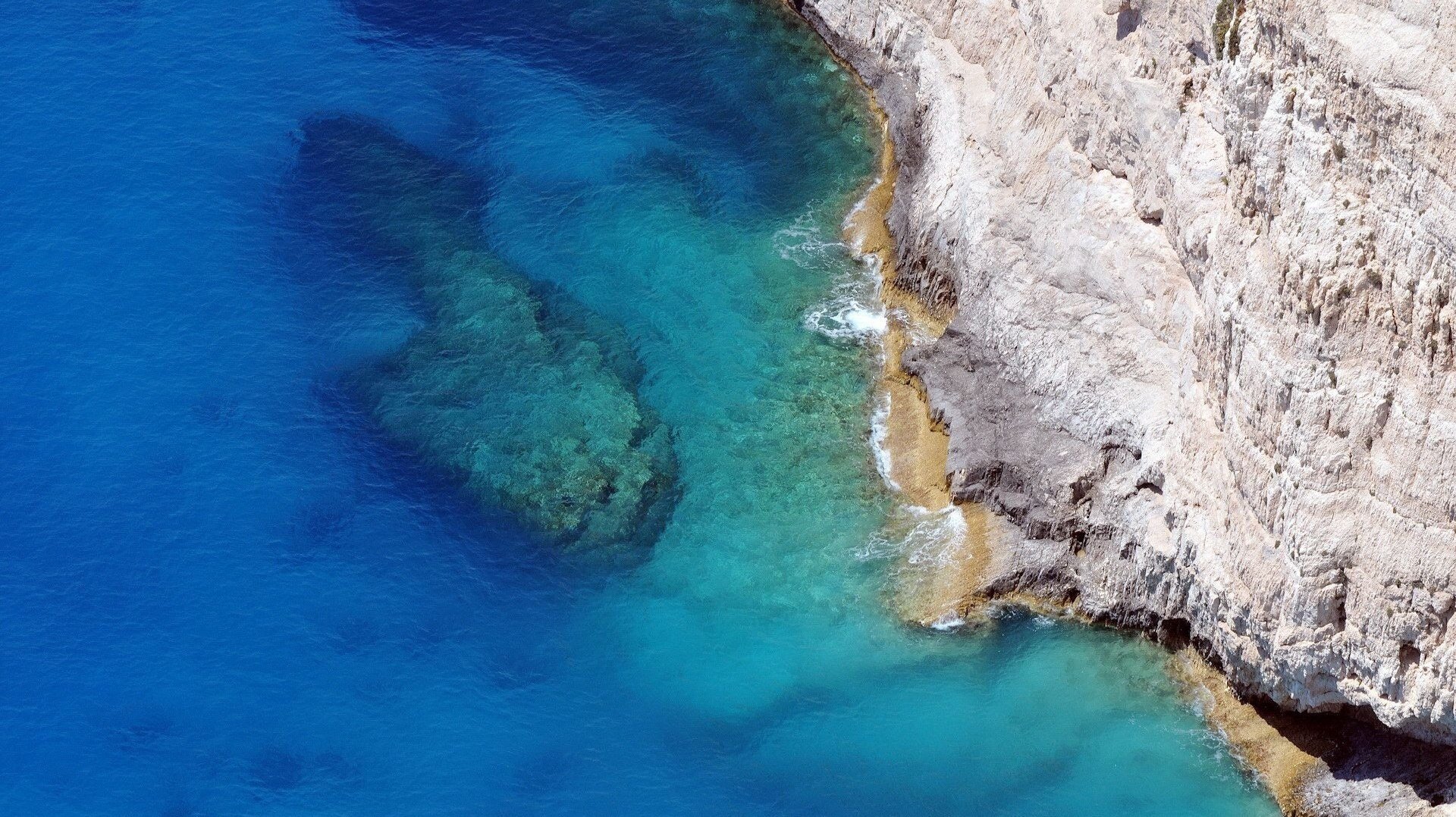 крутой обрыв обрыв каменная скала голубая вода высота море дно прибой берег гладь природа вид остров камни