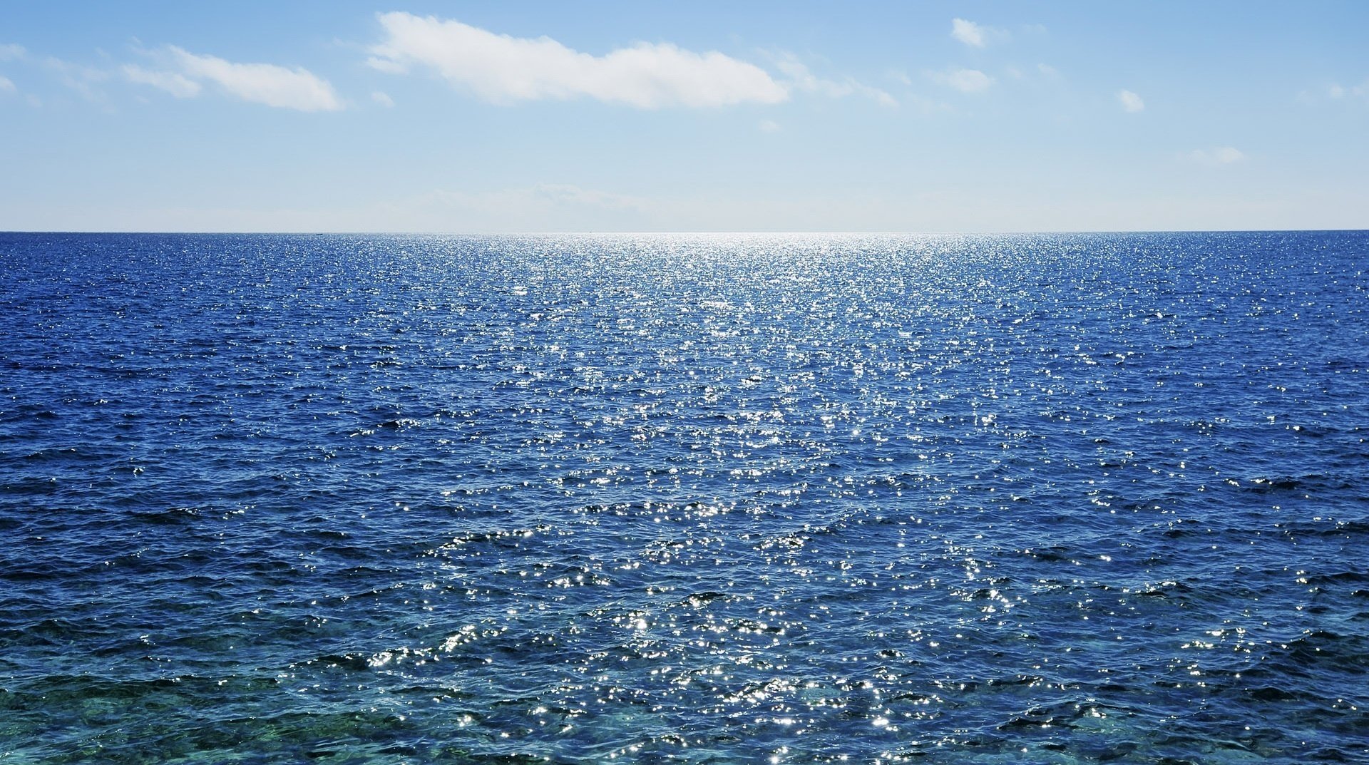 vastas extensiones agua de mar brillo agua verano luz sol ondulaciones horizonte naturaleza mar nubes cielo azul agua azul