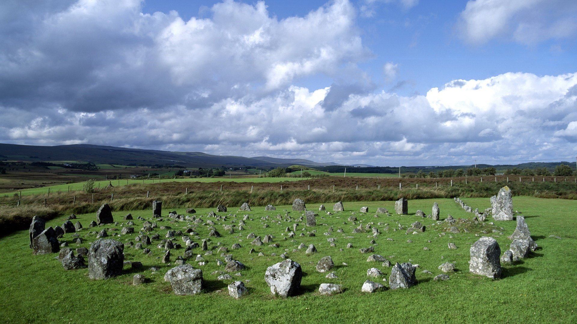 tone circle pieces of stone clearing the sky clouds round fence nature greens summer meadow