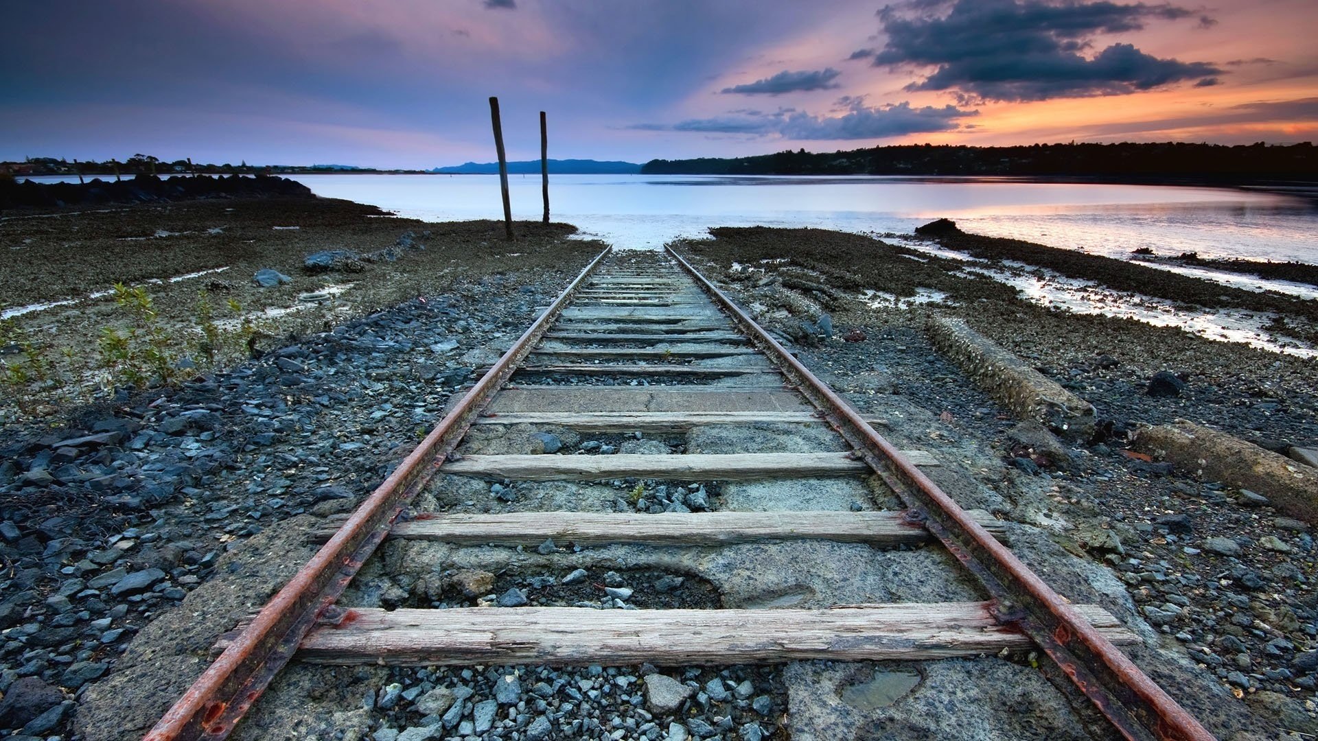 va in acqua strada verso il nulla ferrovia pietre strada tramonto rotaie orizzonte sera lago nuvole ruggine