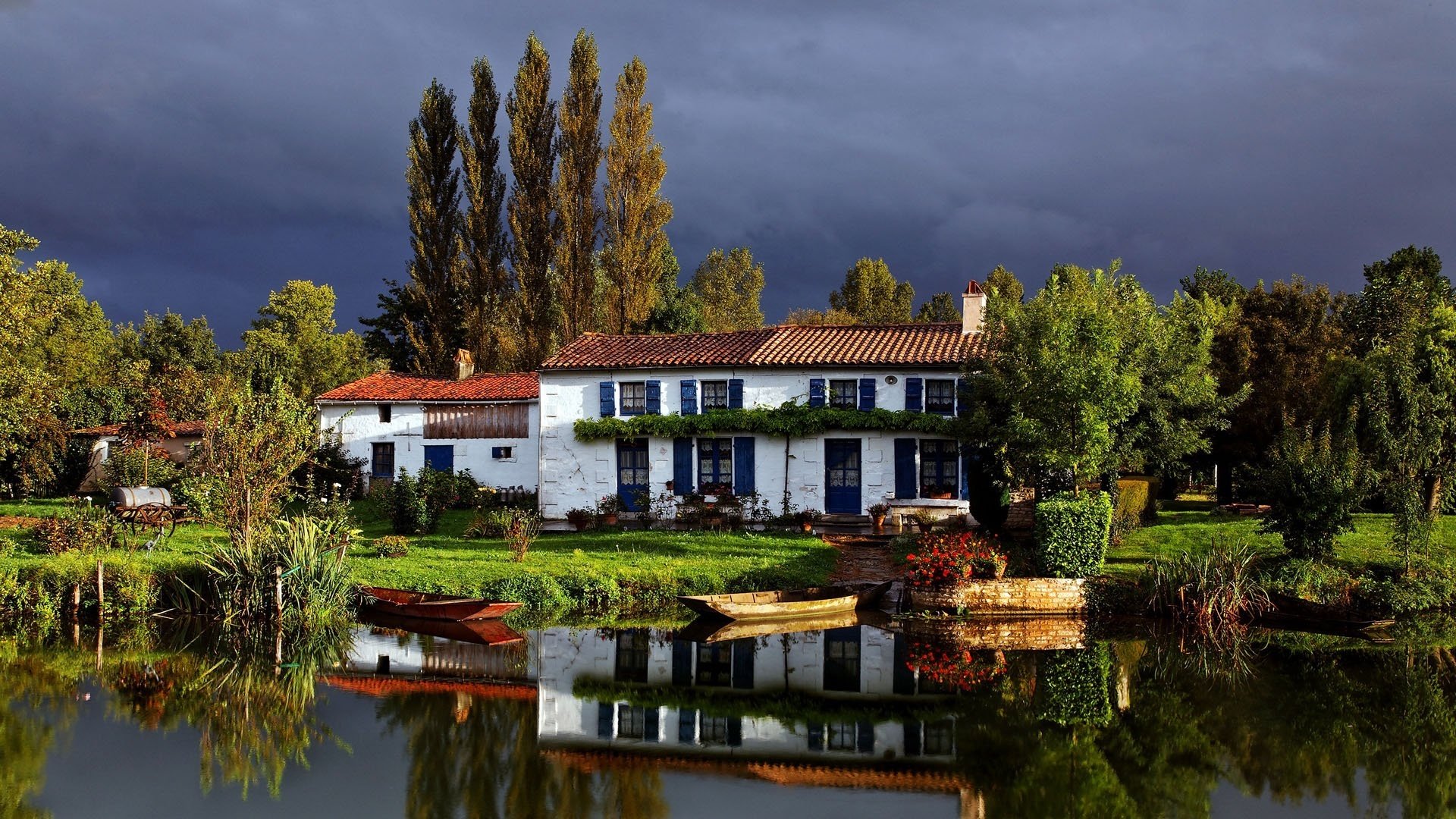 vor einem gewitter blumen gewitterwolken haus am wasser boot häuser gewitter park sommer teich bäume sträucher grün vegetation reflexion