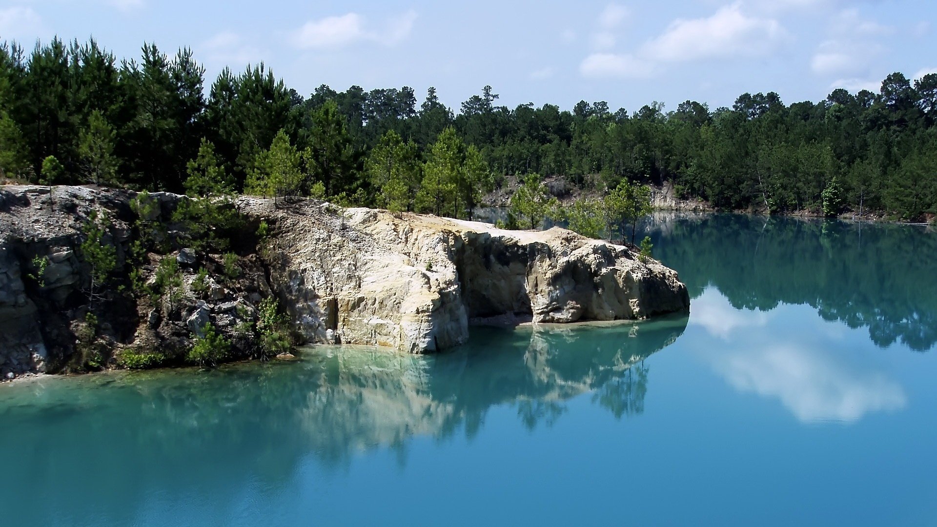 acqua delicatamente blu riva vicino all acqua blocchi di pietra foresta acqua lago natura paesaggio rocce scogliera superficie liscia abete rosso boschetti riva nuvole silenzio calma grazia