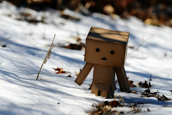 Милый человечек из картона зимой. Тающий снег