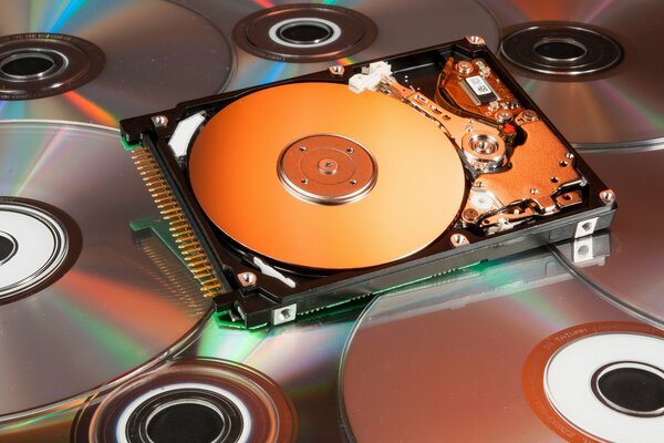 Hard disk lying on the background of CD discs