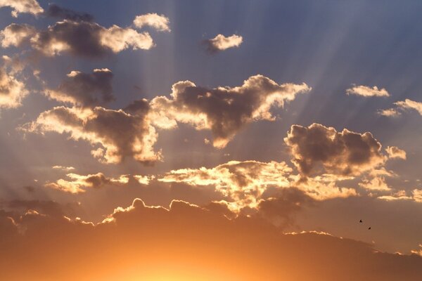 La lumière du soleil se fraye un chemin à travers les nuages au coucher du soleil