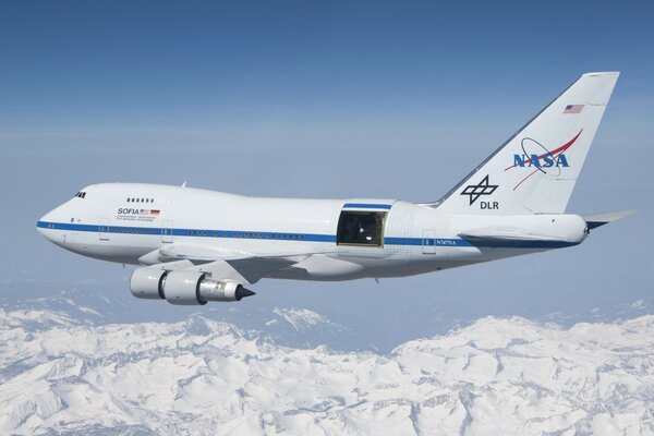 The Boeing plane flies over the mountains