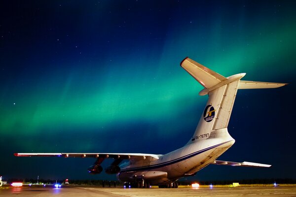The parking of the plane novyu on the background of the northern lights