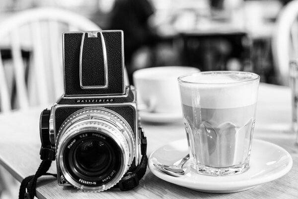 Kamera auf einem Tisch mit Untertasse und Glas