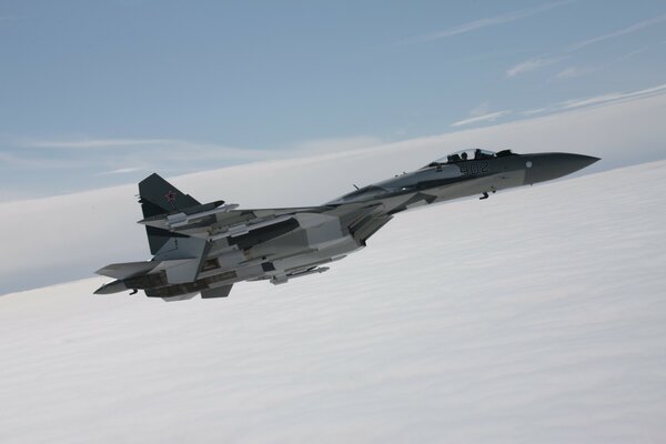 Photo of a fighter plane in the sky above the clouds