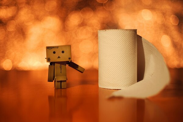 A cardboard man stands next to a roll of toilet paper