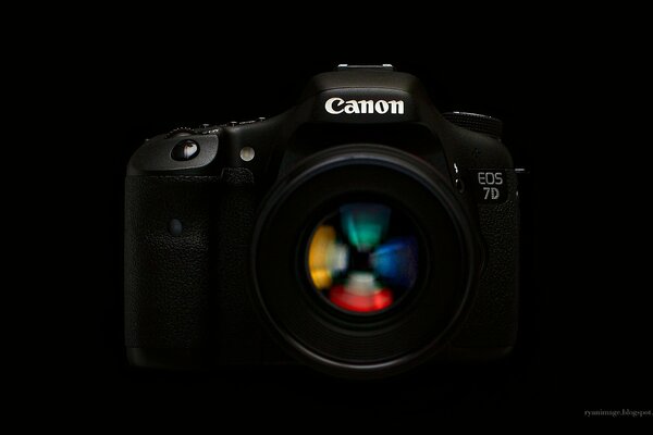 Зеркальный фотоаппарат canon на черном фоне