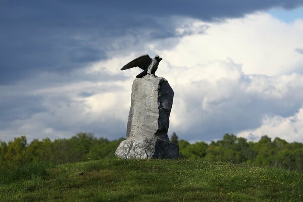 Estatua de piedra del águila con vegetación alrededor