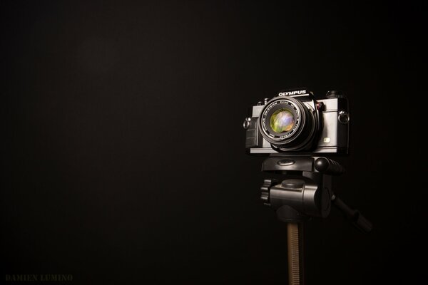 A camera on a metal holder on a black background