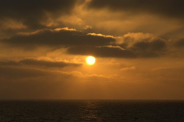 Orange Sonnenuntergang und dunkle Wolken