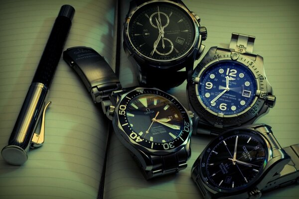 Plusieurs montres-bracelets se trouvent sur un cahier ouvert