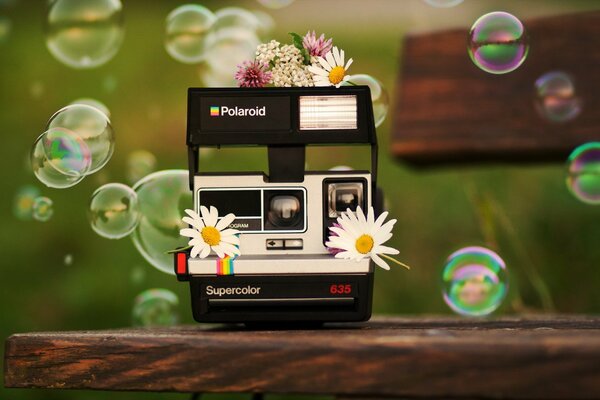 Polaroid camera on the background of soap bubbles