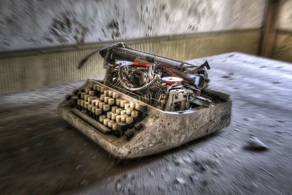 An ancient typewriter on a dirty floor