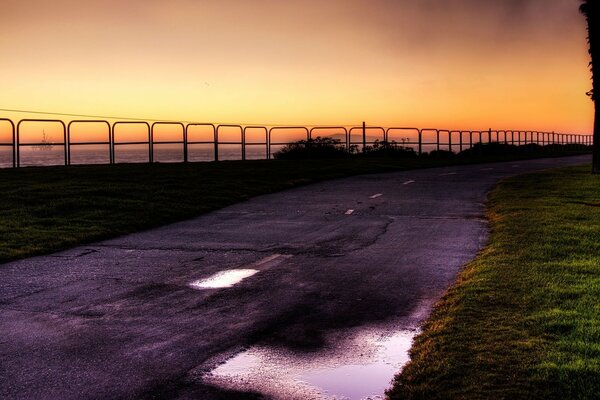 A road with puddles along the shore