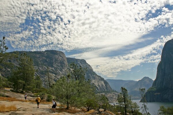 Touristen gehen auf Felsen, ein außergewöhnlicher Himmel