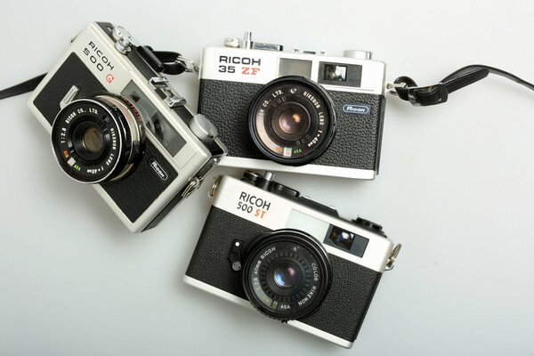 Three cameras on a gray background