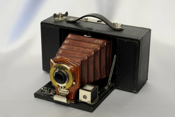 Старинный складной фотоаппарат на светлом фоне