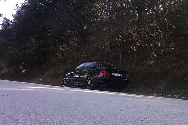 Voiture noire sur la route sur fond de forêt