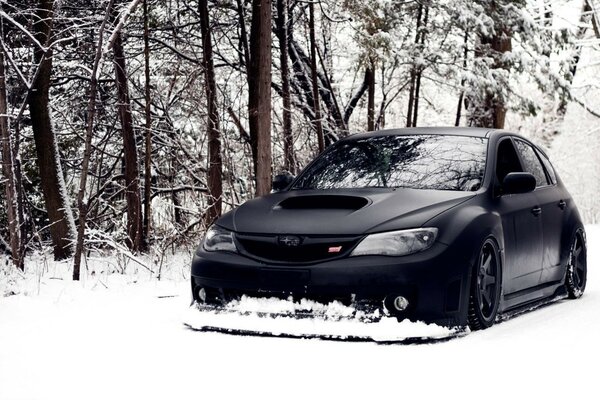 Black Subaru Impreza with lowered suspension in winter