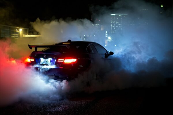 A car with smoke and lights on the background of houses