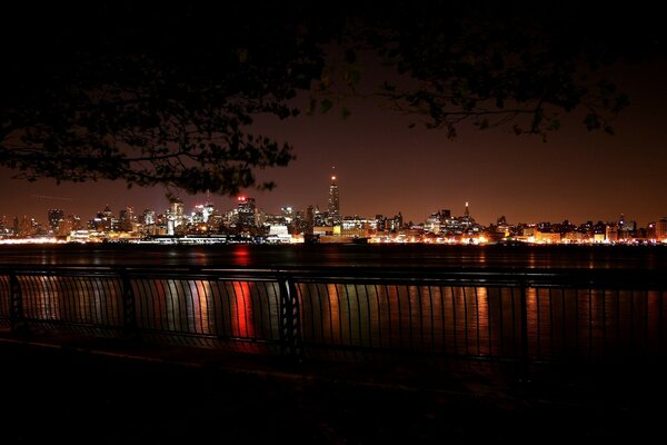 The night embankment glitters on the water