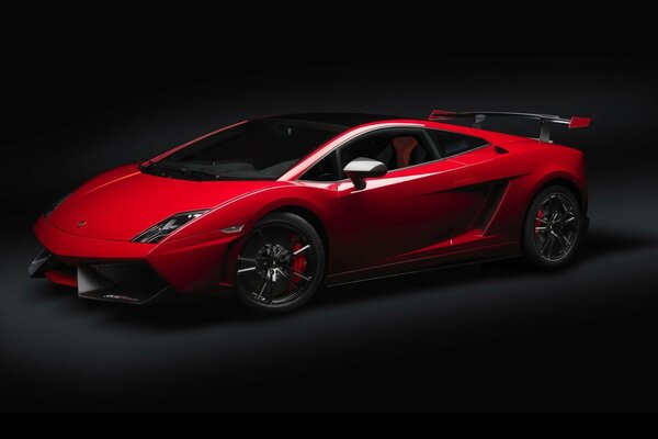 A sporty red car on a black background