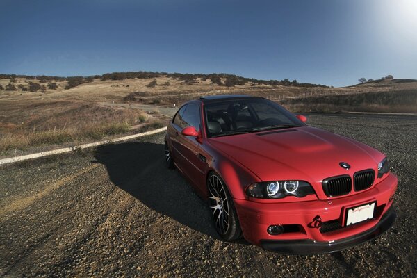 Red BMW car on a rocky road