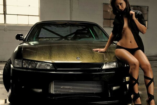 Hermosa supermodelo posando con un coche nissan