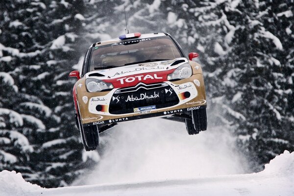 Auto da corsa da rally Citroen sullo sfondo della foresta in inverno nel salto