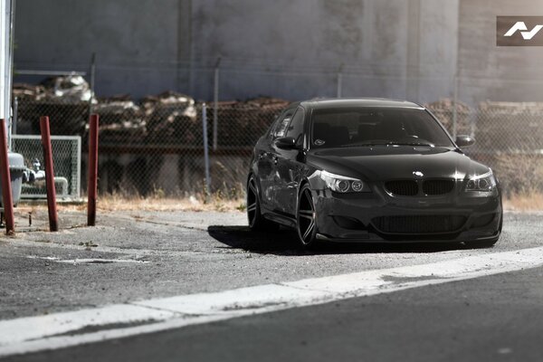 Black daring BMW e60 on the road