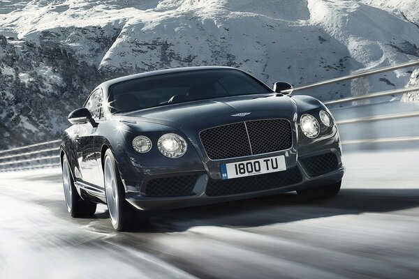 Bentley supersports auf der Straße vor dem Hintergrund von schneebedeckten Felsen