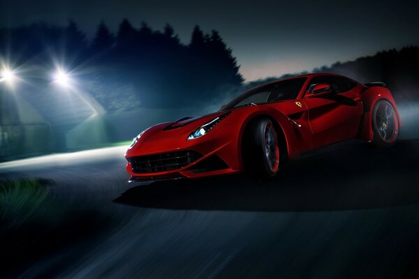 Czerwony samochód Ferrari, na tle płoną światła