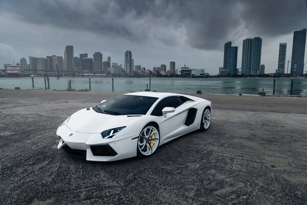 Coche Lamborghini aventador blanco en el fondo de la ciudad