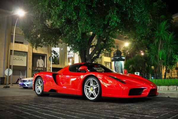 Un poderoso ferrari en el crepúsculo de una gran ciudad