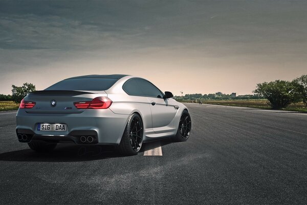 Un bmw gris en la carretera que se aleja