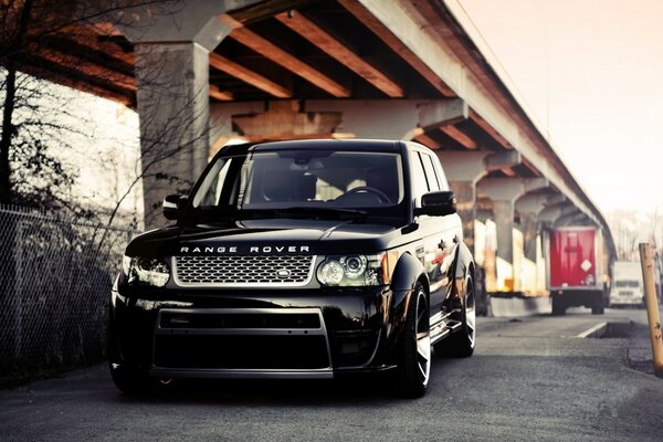 Rang Rover nero su cerchi eleganti sotto il ponte