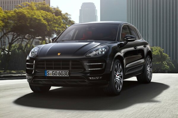 Porsche Macan noir sur fond de métropole