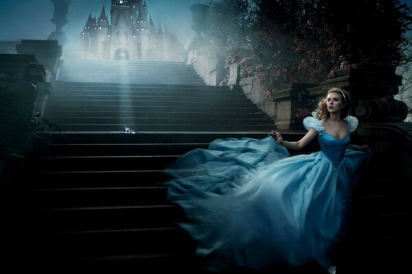 Cinderella scarlet Johanson in a blue outfit runs down the stairs of the castle