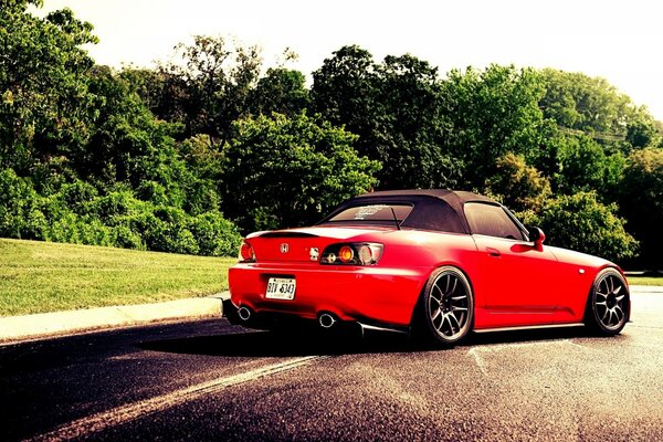 Honda s2000 su una lunga pista vicino alla foresta