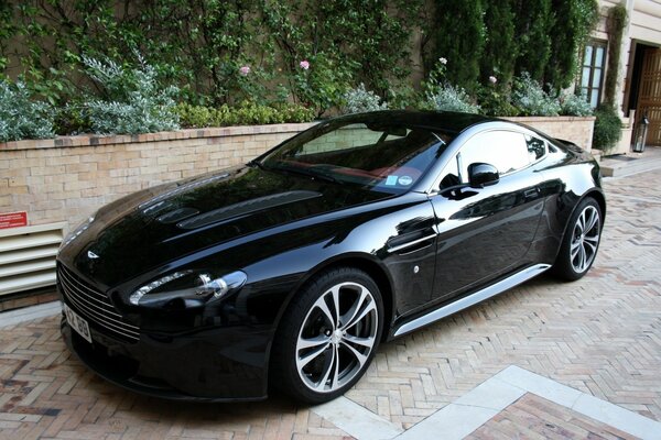 Black car, vantage, aston martin on the sidewalk