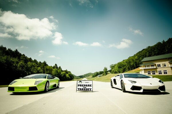 Two green and white Lambirghini supercars on the track