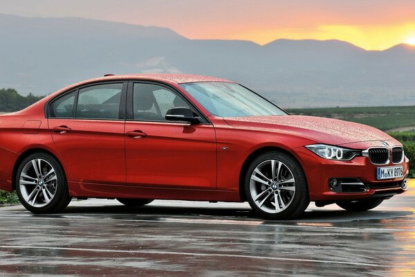 Red bmw, sedan on wet asphalt