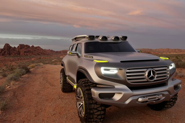 Mercedes benz dans le désert avec les lumières allumées