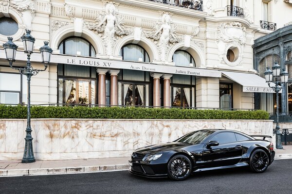 A black Mercedes is parked on the street