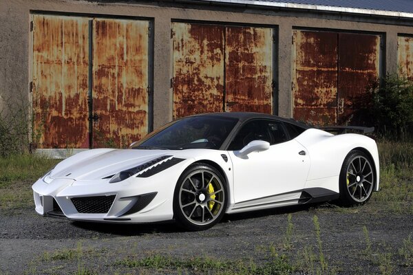 Ferrari blanche avec toit noir sur fond de garages